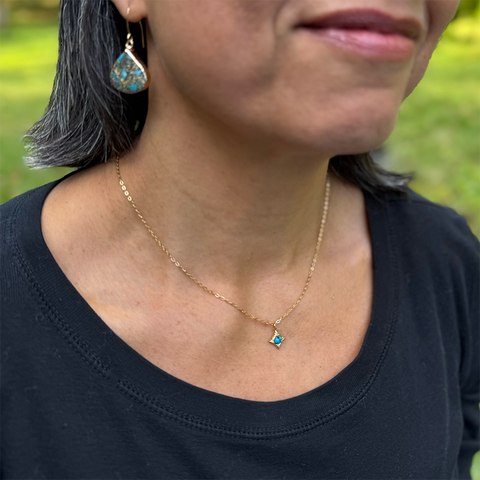 Gold-plated tiny compass necklace with turquoise stone in the center. 