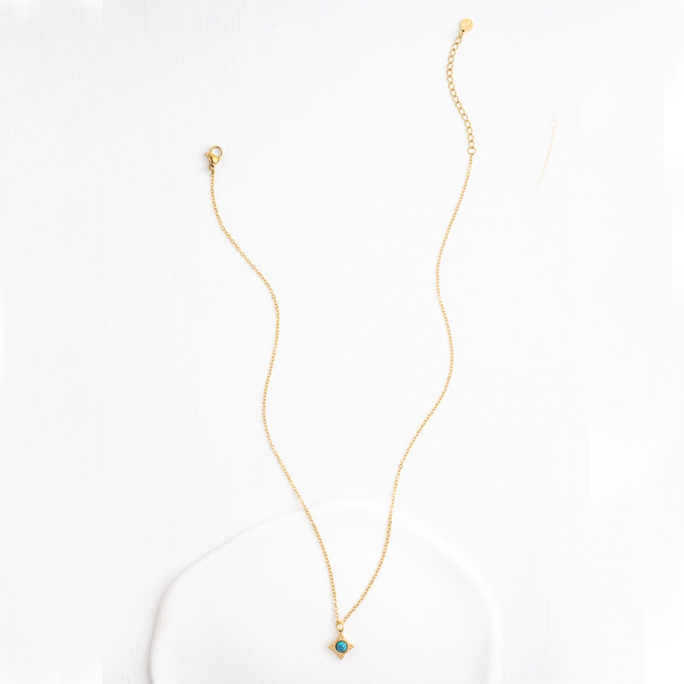 Gold-plated tiny compass necklace with turquoise stone in the center. 