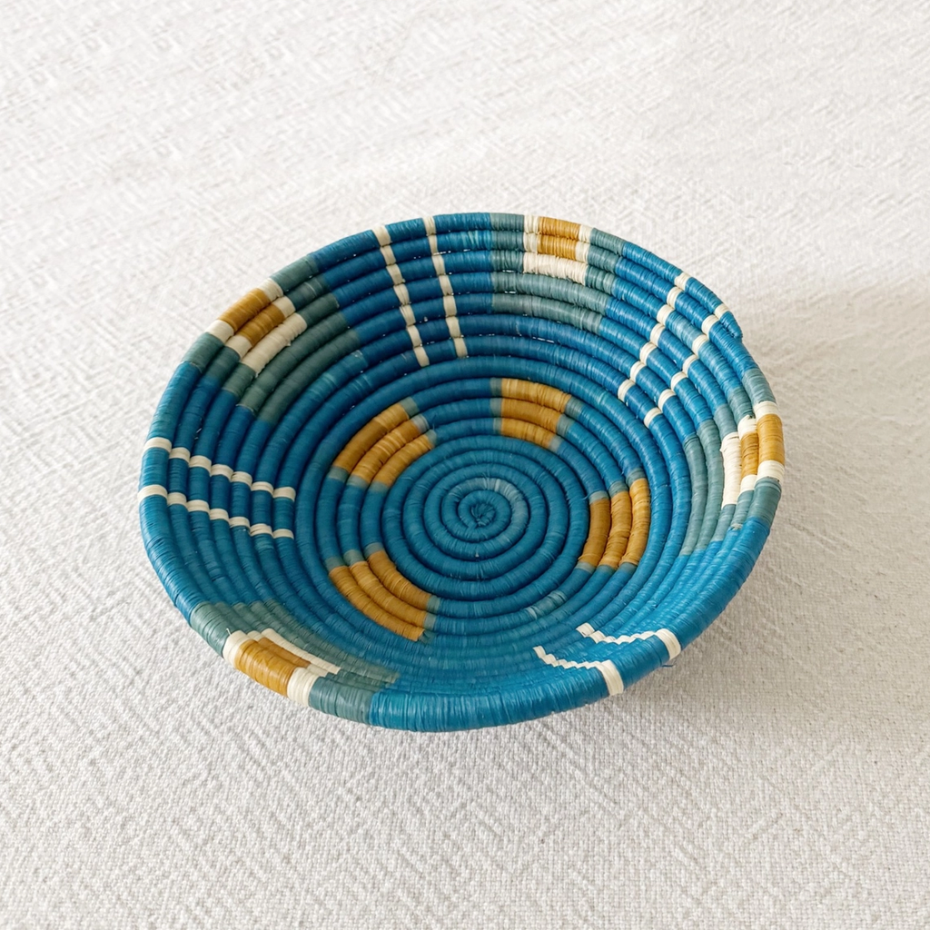 Round handwoven basket with blue background and orange squares and light green