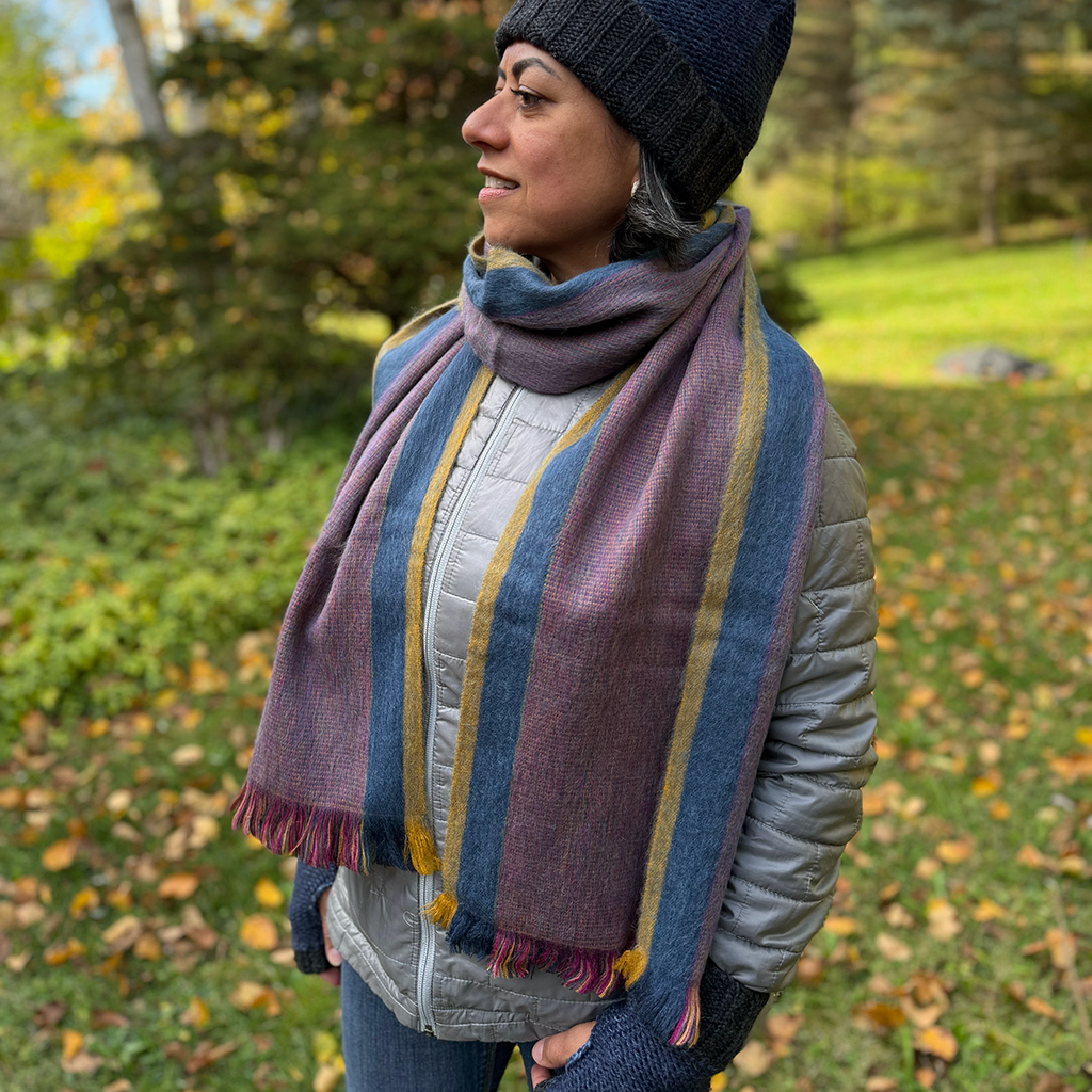Mauve, blue and yellow alpaca scarf on model 