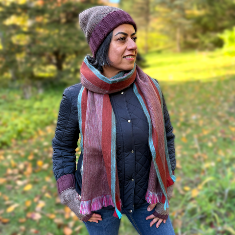 Model showing alpaca scarf with reds and turquoise colors stripes
