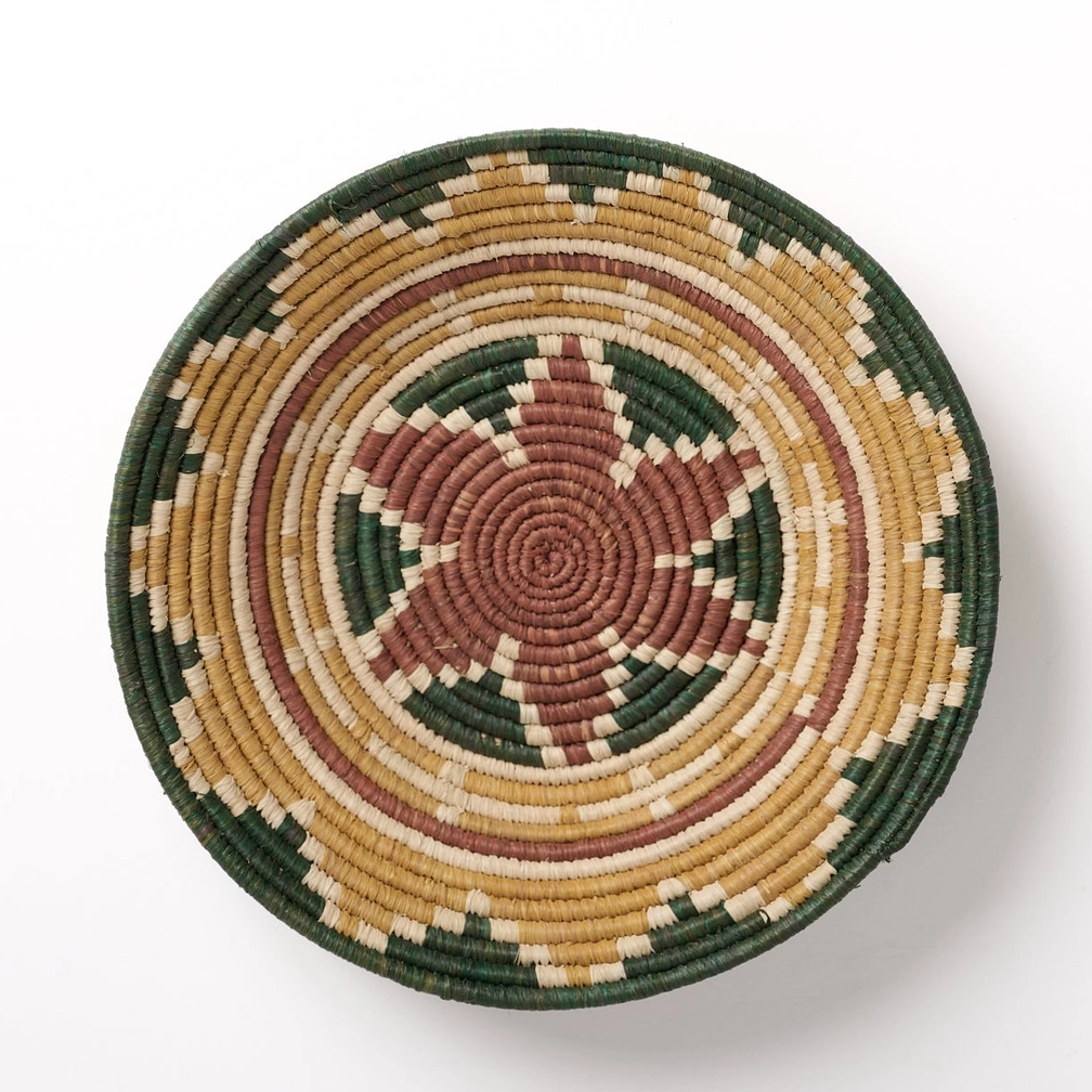 Round banana fiber basket with star petal design in brown, tan and green