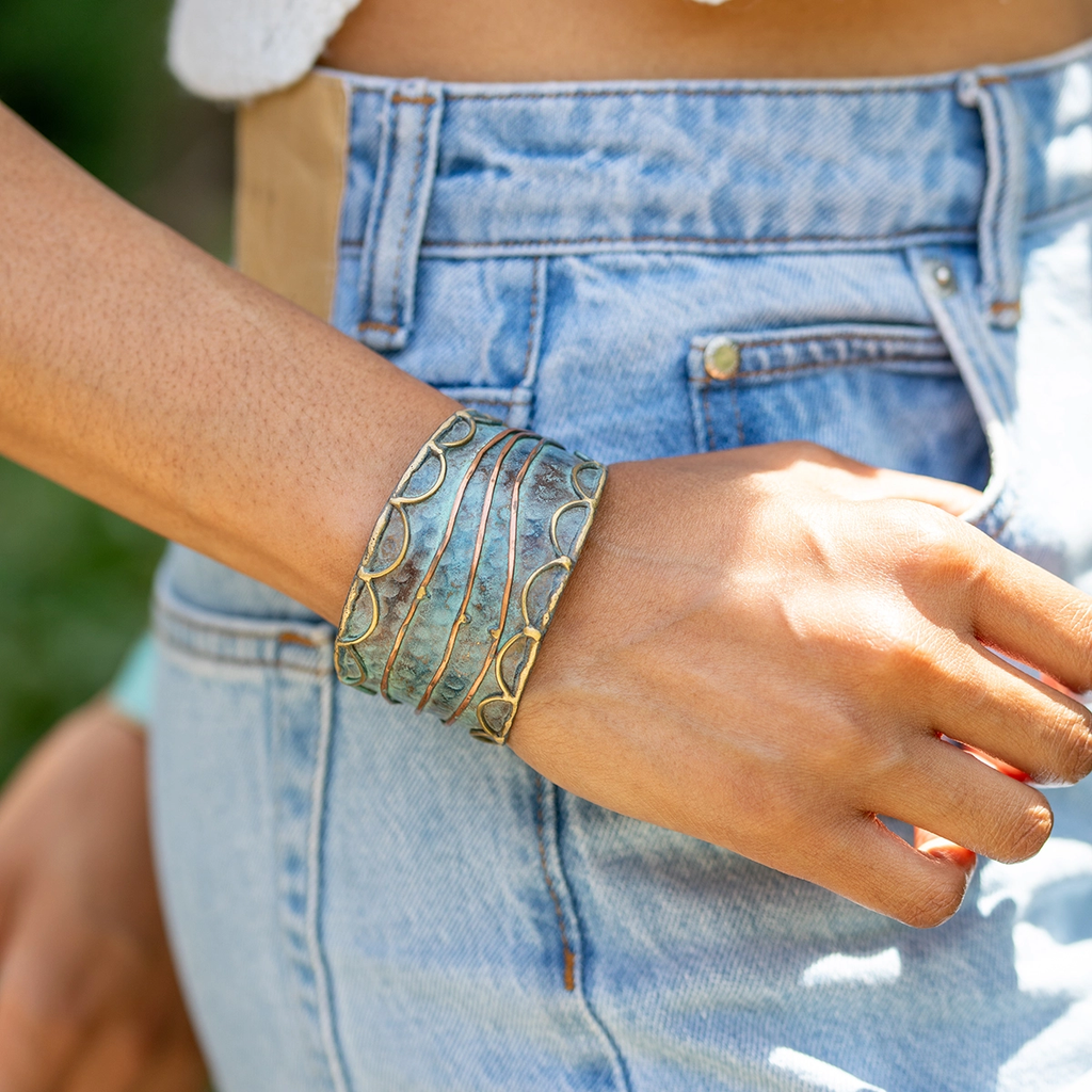 Blue brass patina wide cuff with gold and copper line design.