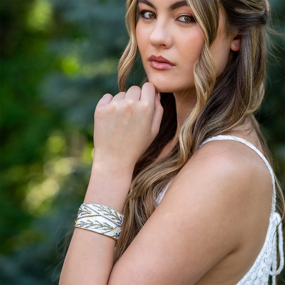 White and brass cuff with patina finish and brass leaf accents.