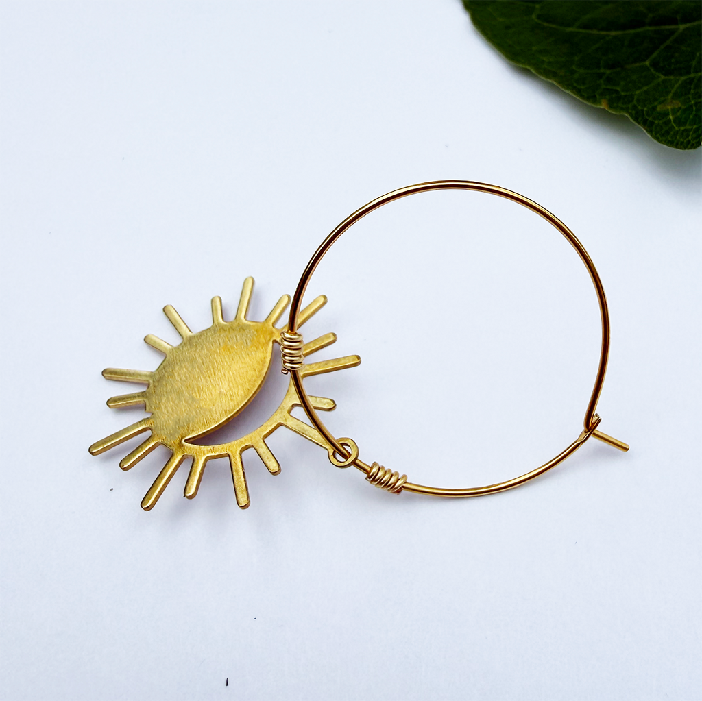 Brass hoop earrings with eclipse charm on the bottom