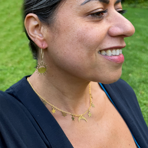 Brass hoop earrings with eclipse charm on the bottom