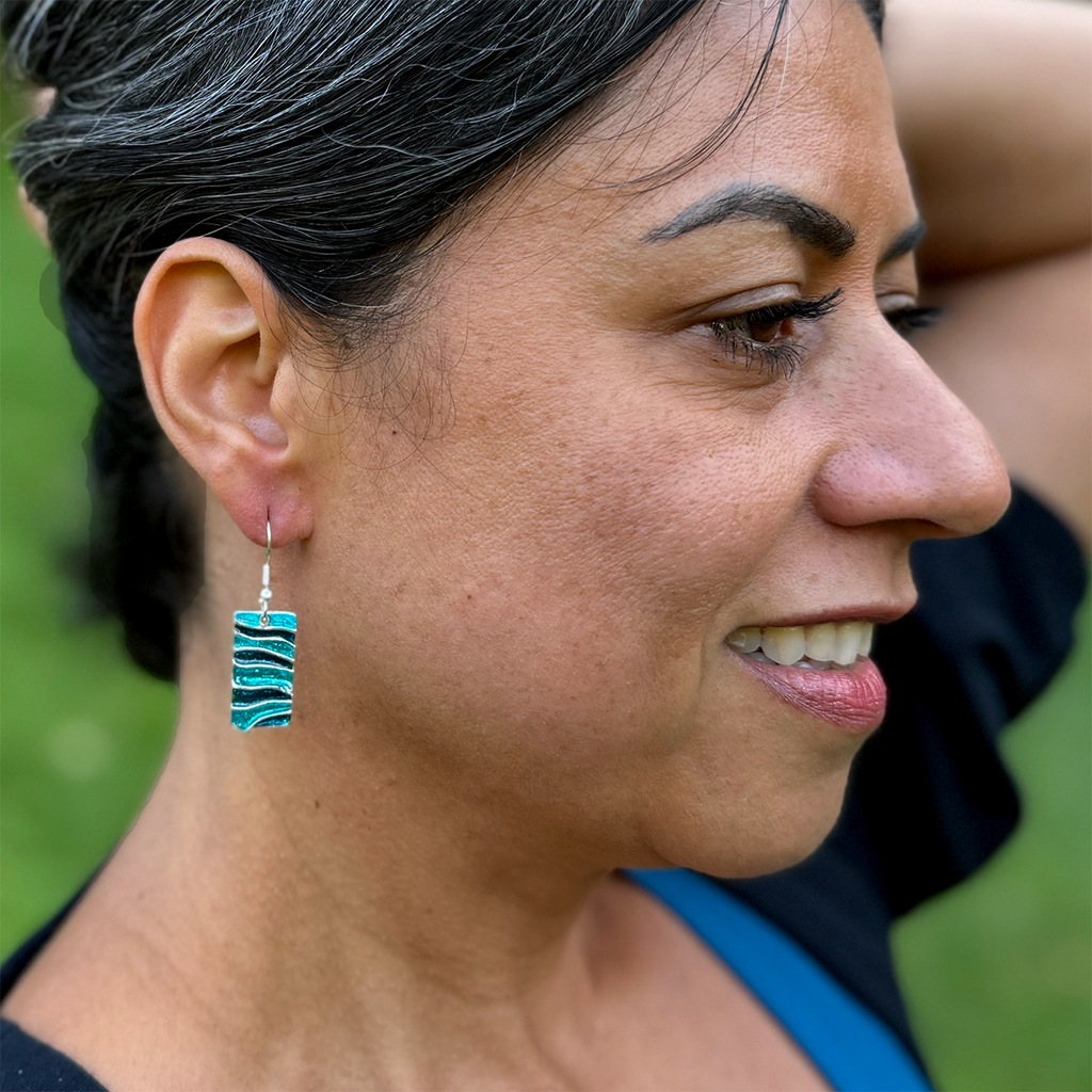 Rectangle shaped pewter earrings with blue wave enamel design on model