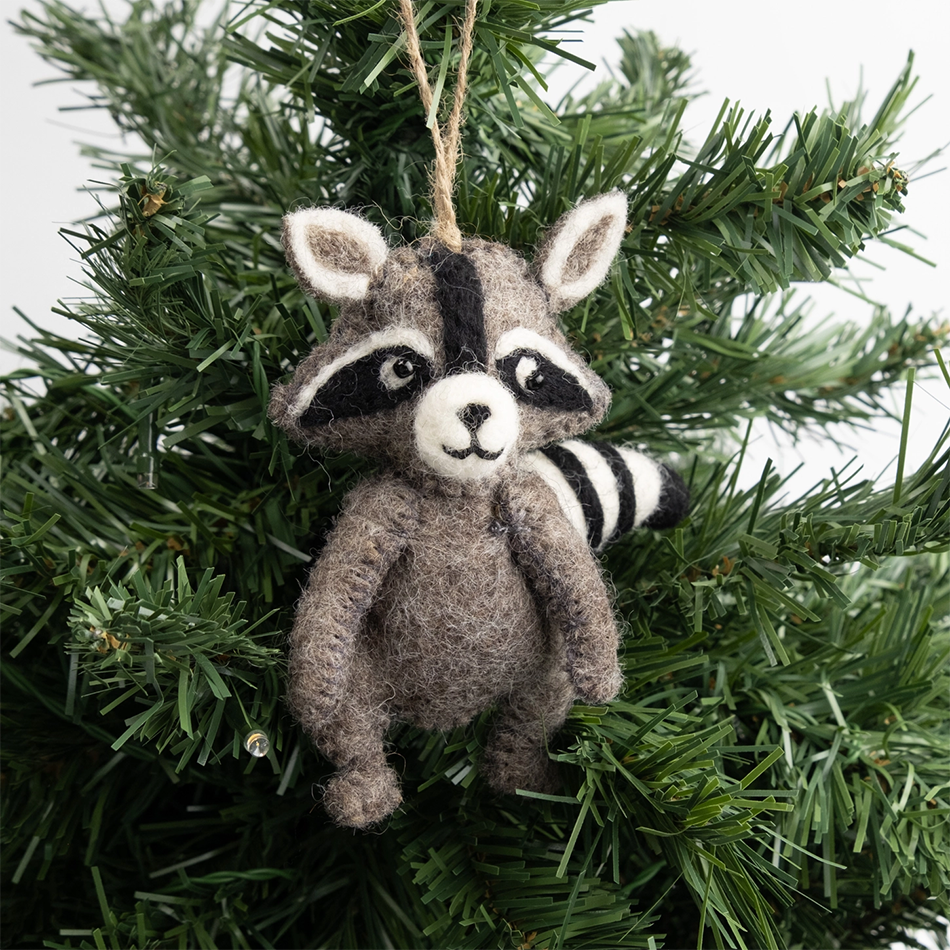 Felted gray raccoon ornament on pine tree