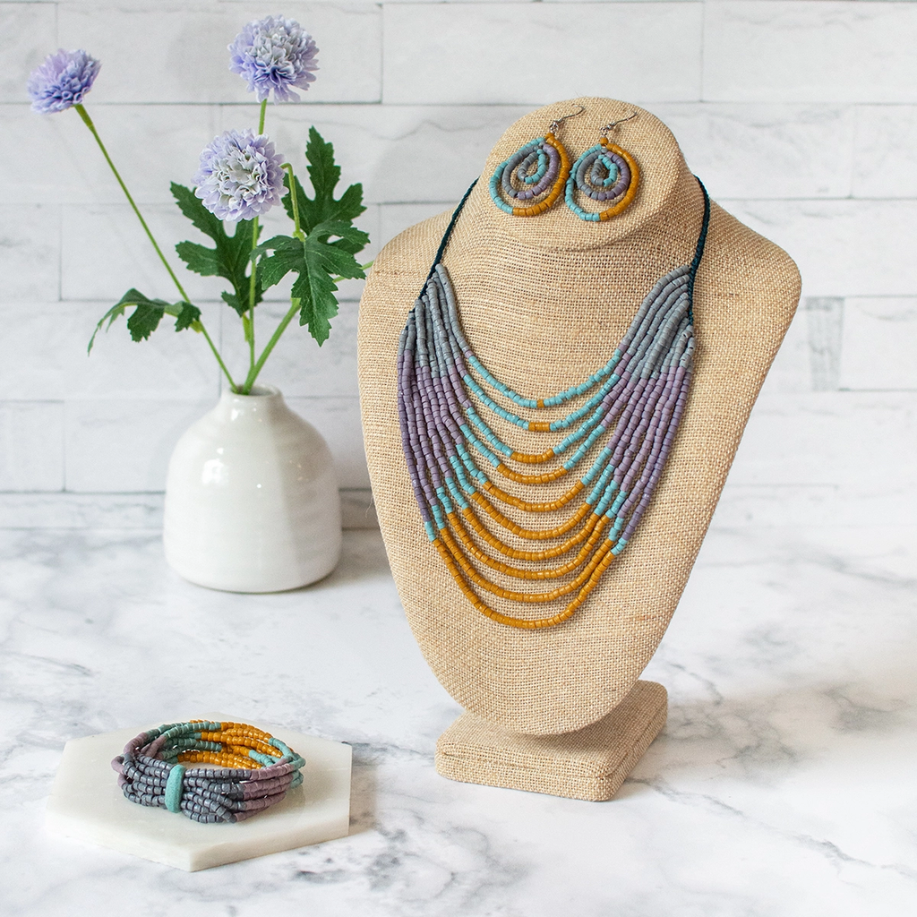 Glass bead statement necklace with multiple strands of orange, turquoise, gray and purple beads.