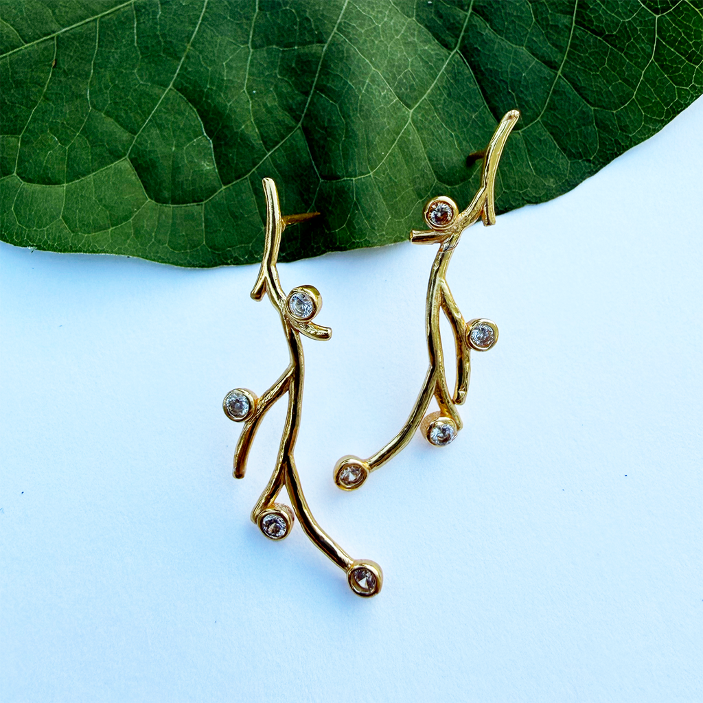 Gold post earrings with branches and zircon stones.