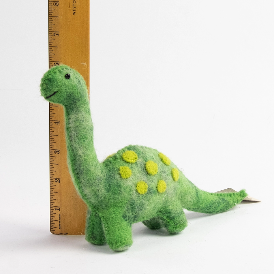 Green felt dinosaur next to ruler