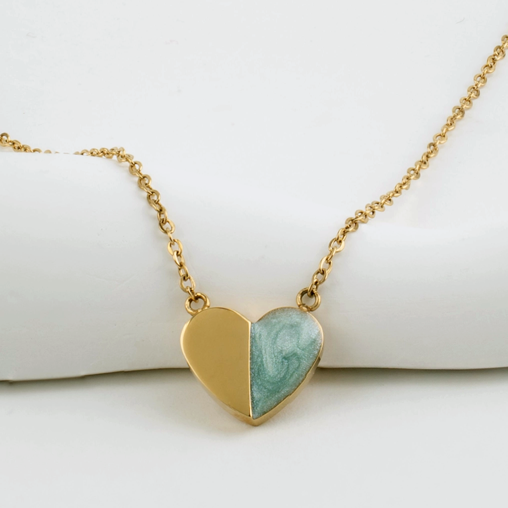 Necklace with a heart pendant that is half gold, half green enamel with delicate gold chain.