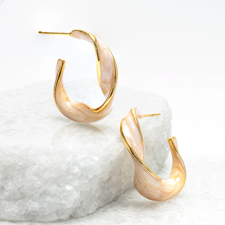 Gold huggie style earrings with a tangerine colored, shiny enamel