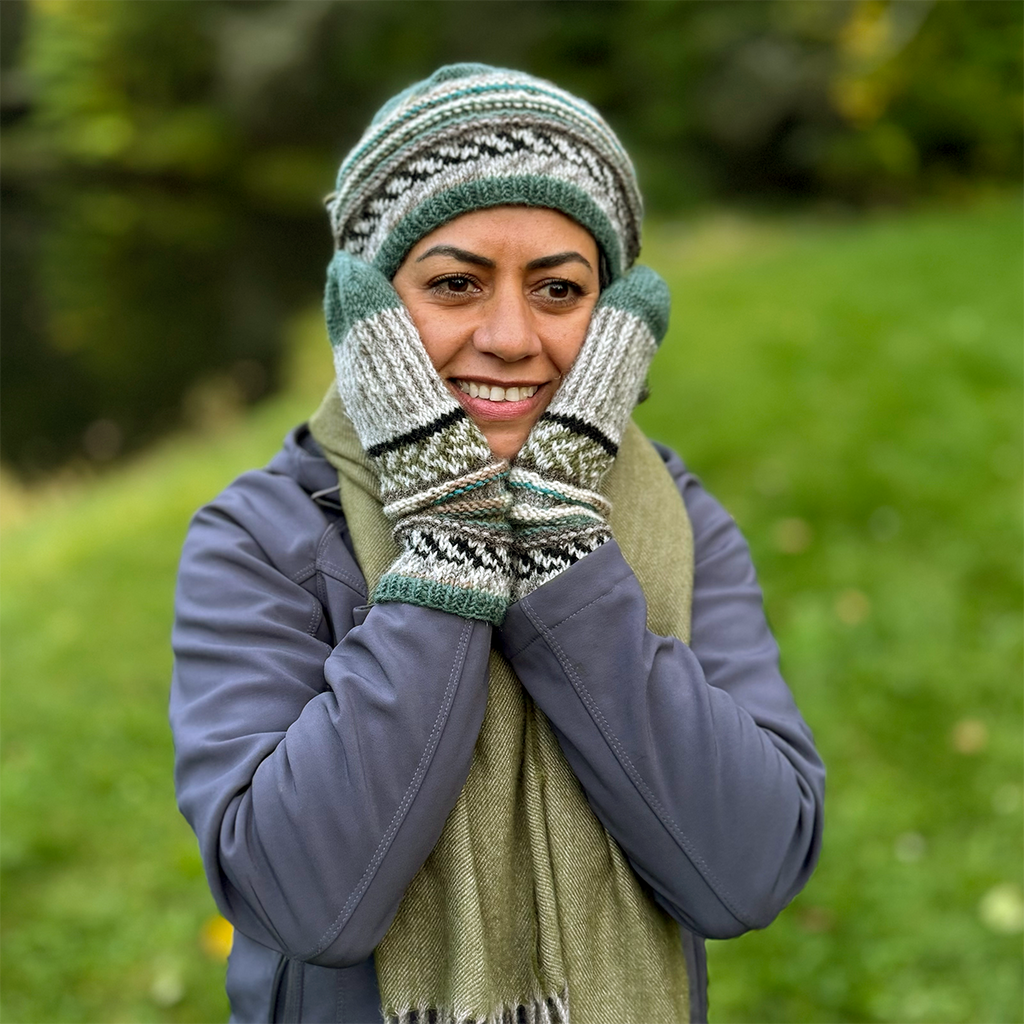 Handknit wool mittens with green, brown, cream colored design on model