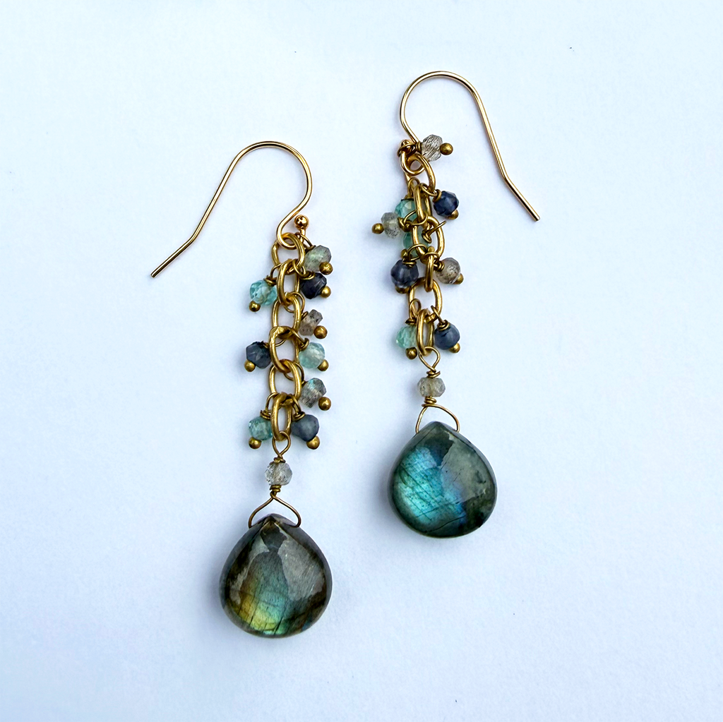 Earrings with a cluster of tiny labradorite stones and one teardrop shaped larger stone on the bottom with brass.
