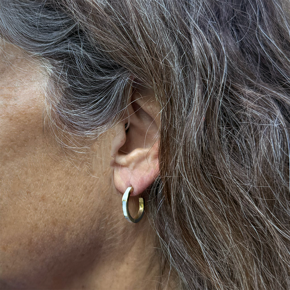 mother-of-pearl huggies earrings on model