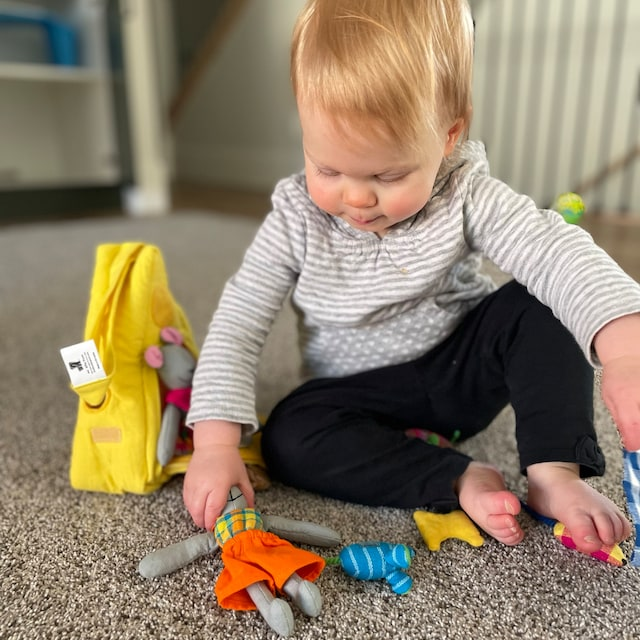 Young child playing with a cotton play set on the floor