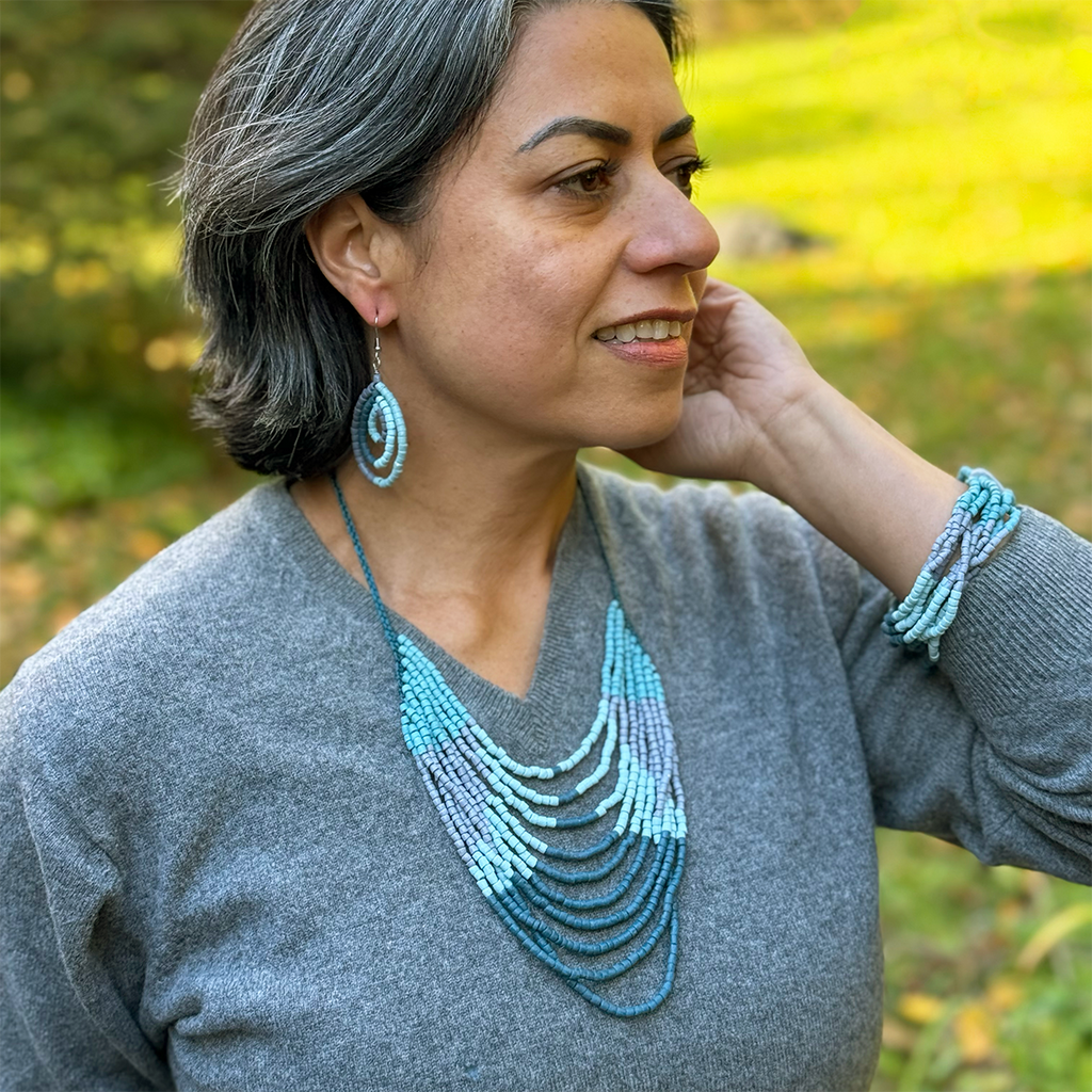 Jewelry set of necklace, earrings and bracelet made of glass beads in blue and gray colors on model