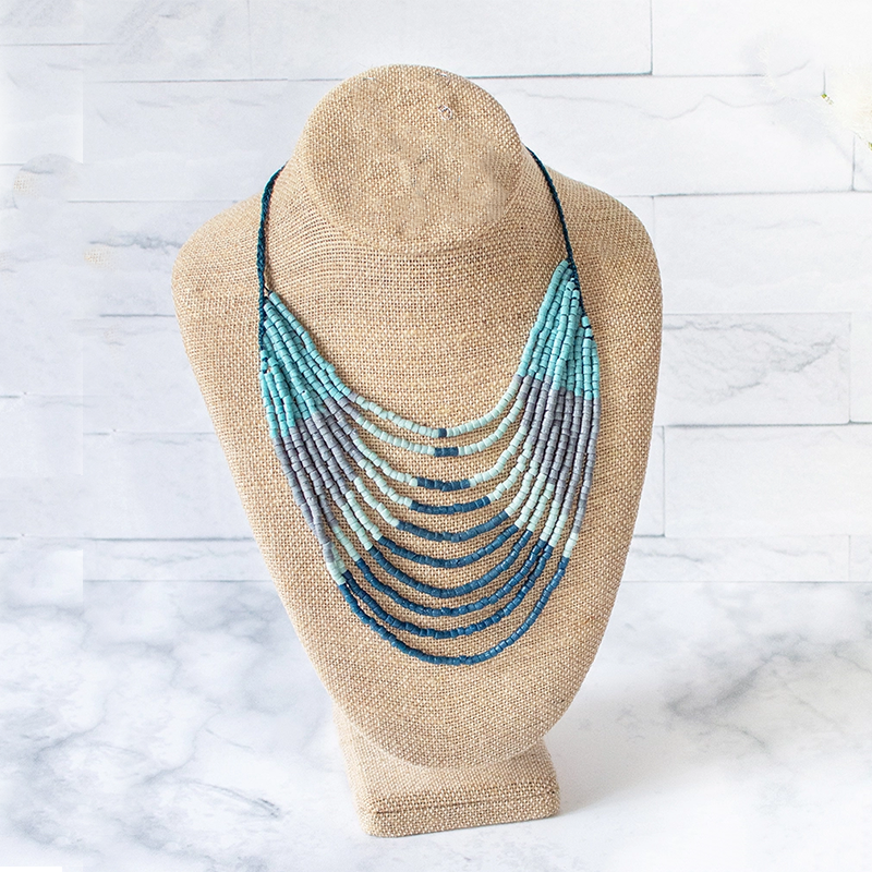 Glass bead necklace with multiple strands of blue gray and white.