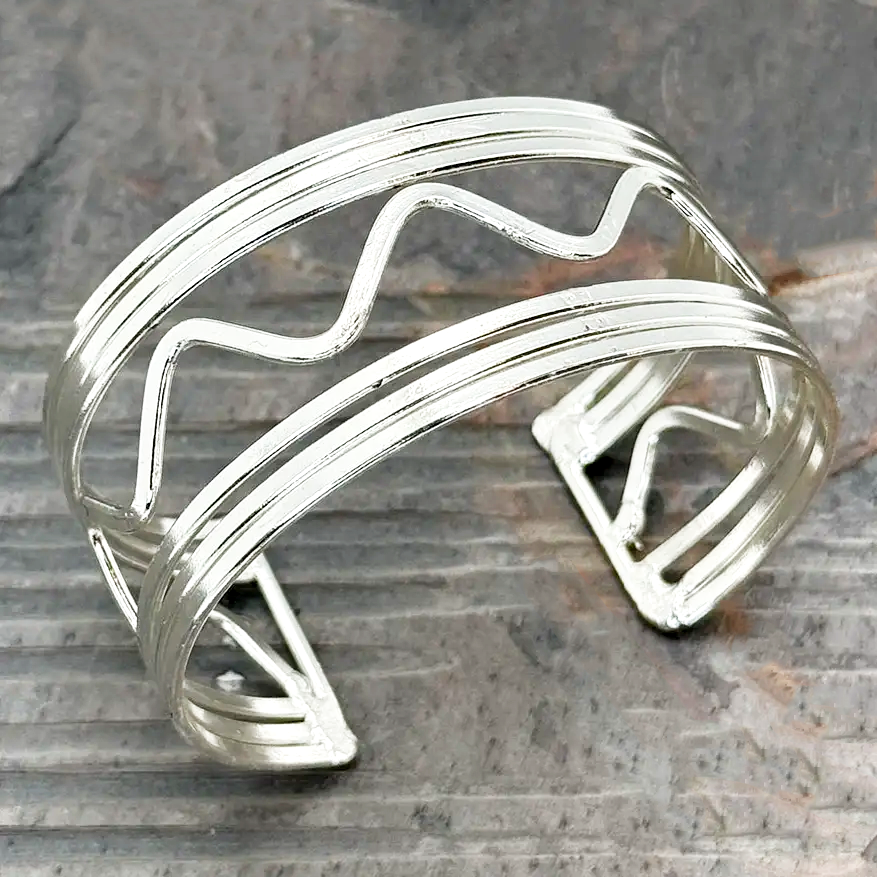 Wide silver cuff bracelet with wavy design.