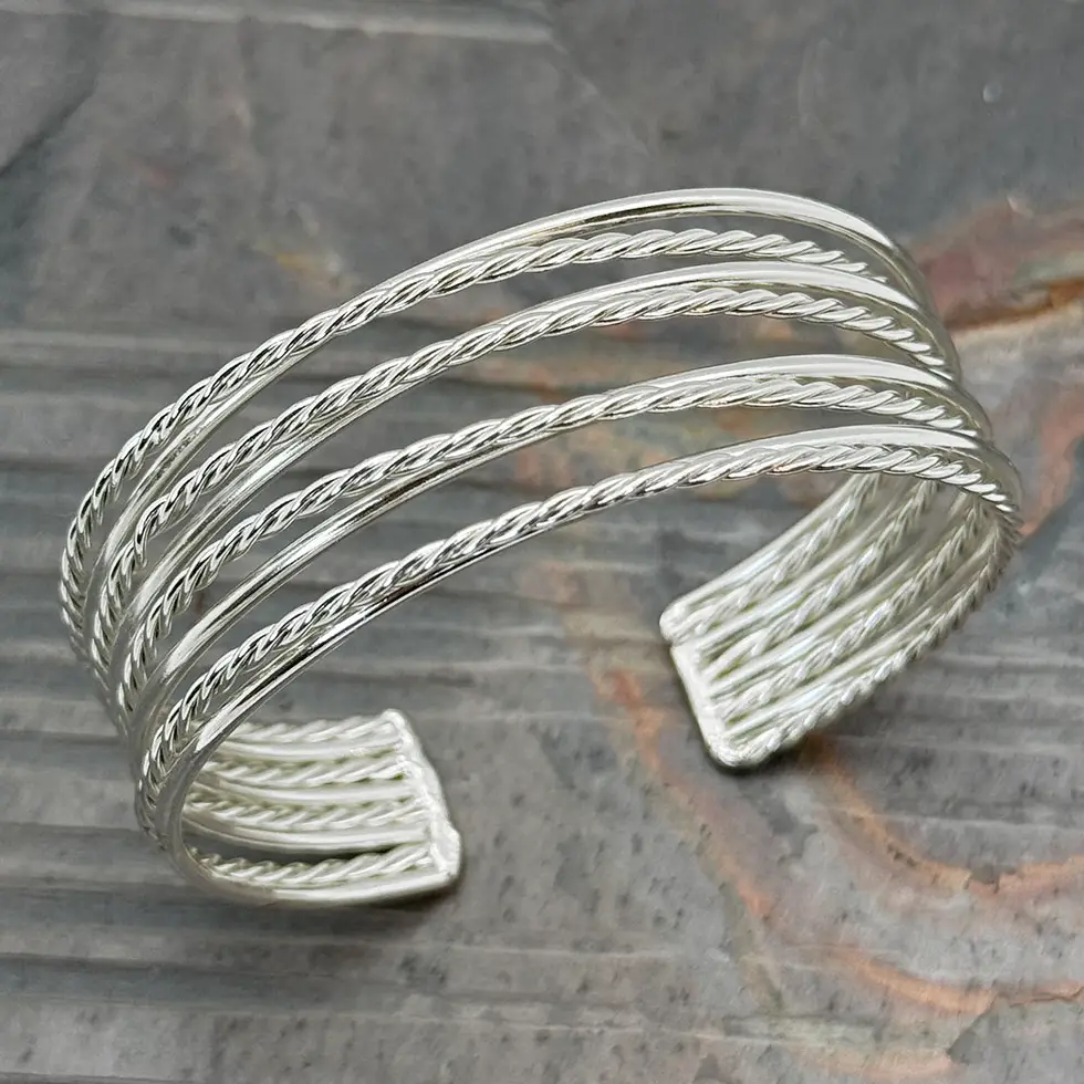 Silver cuff bracelet with several strands of twisted silver metal.