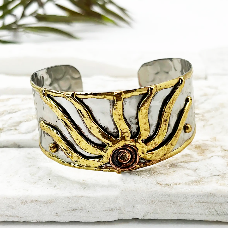 Silver-plated wide cuff with gold sun design.