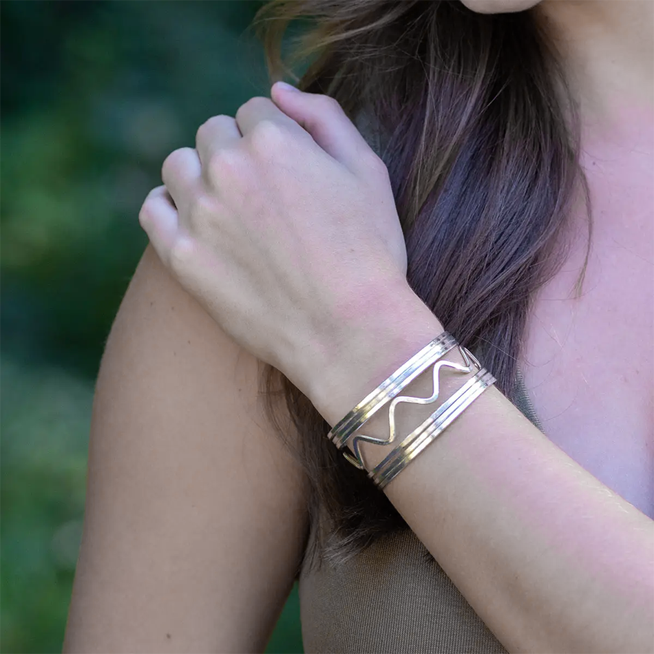 Wide silver cuff bracelet with wavy design.