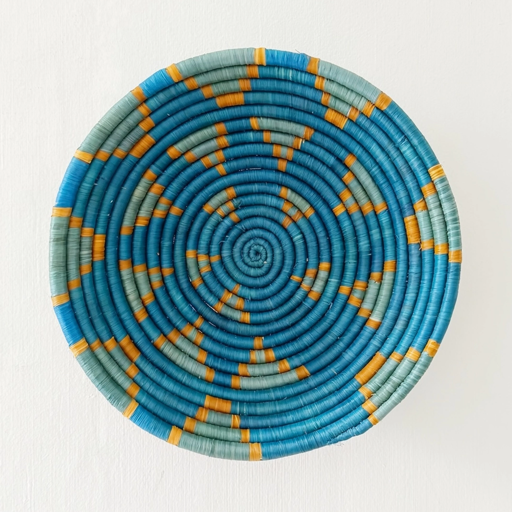 Round handwoven basket with blue star design and orange trim
