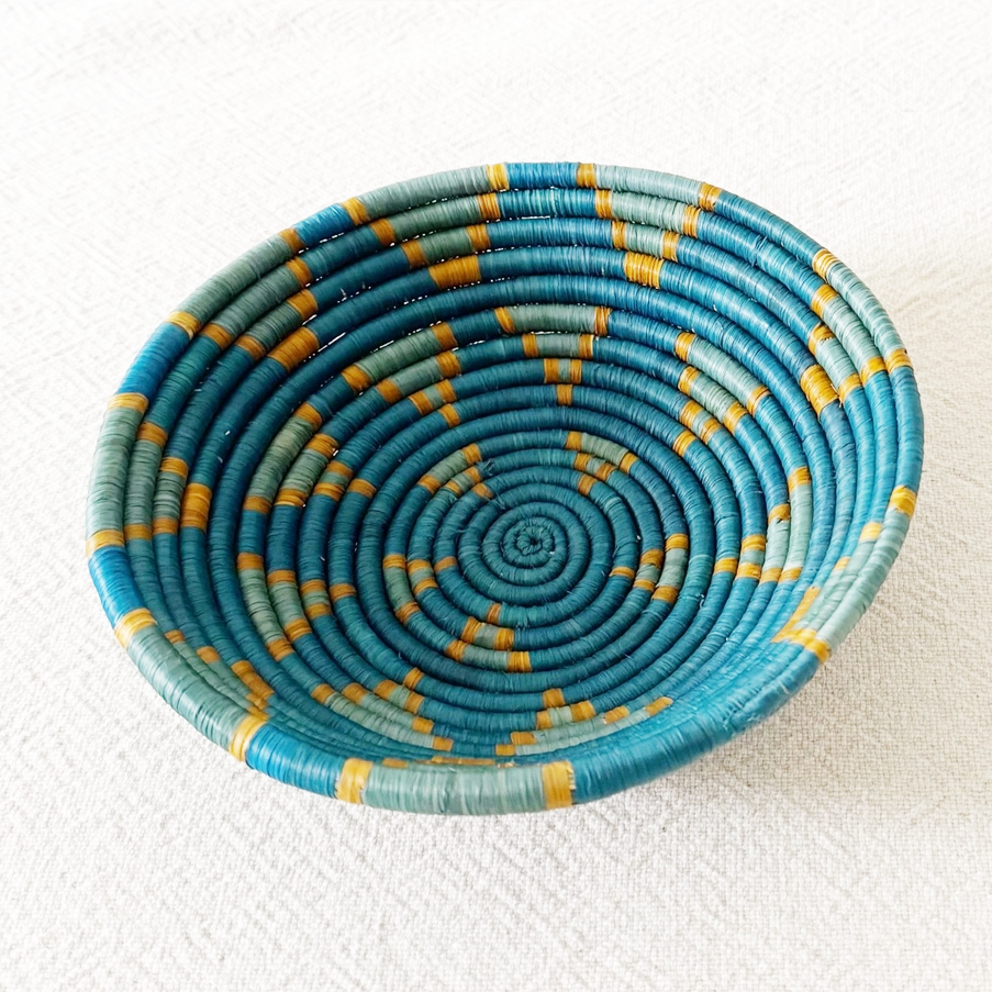 Round handwoven basket with blue star design and orange trim