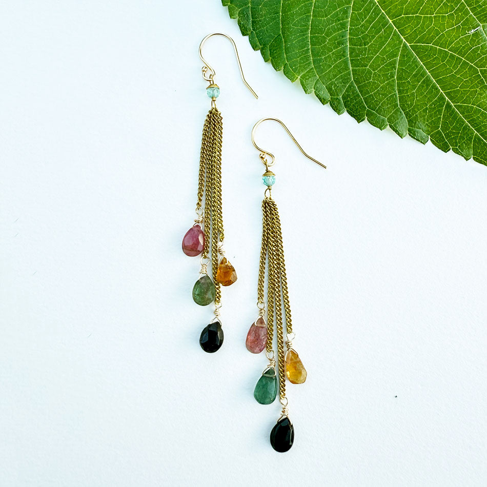 Fair trade earrings featuring colorful tourmaline stones and brass chains.