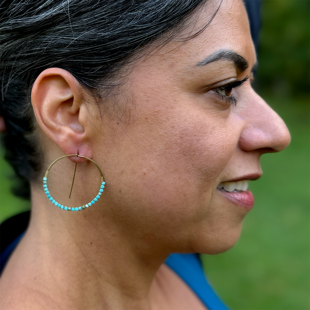 Brass hoops with tiny turquoise stones on model