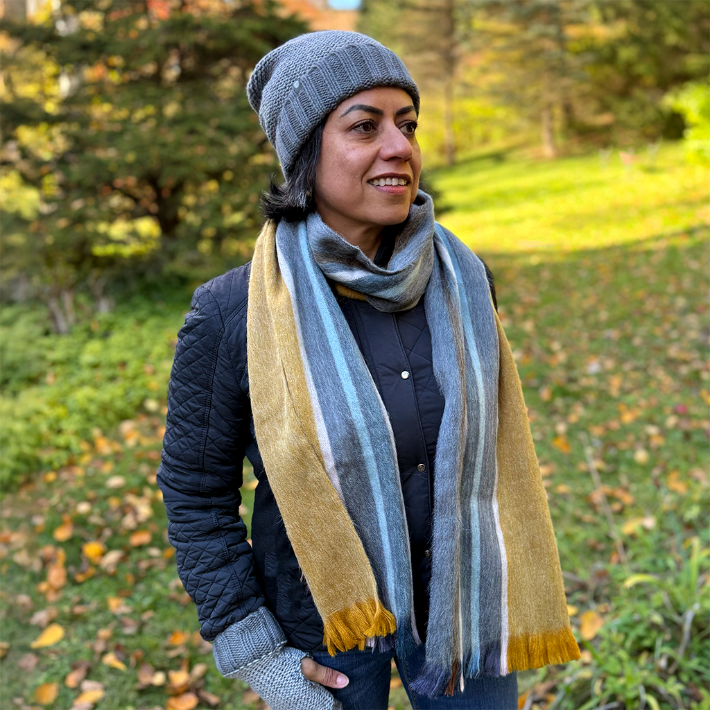 Alpaca scarf on model with gold, gray and blue stripes