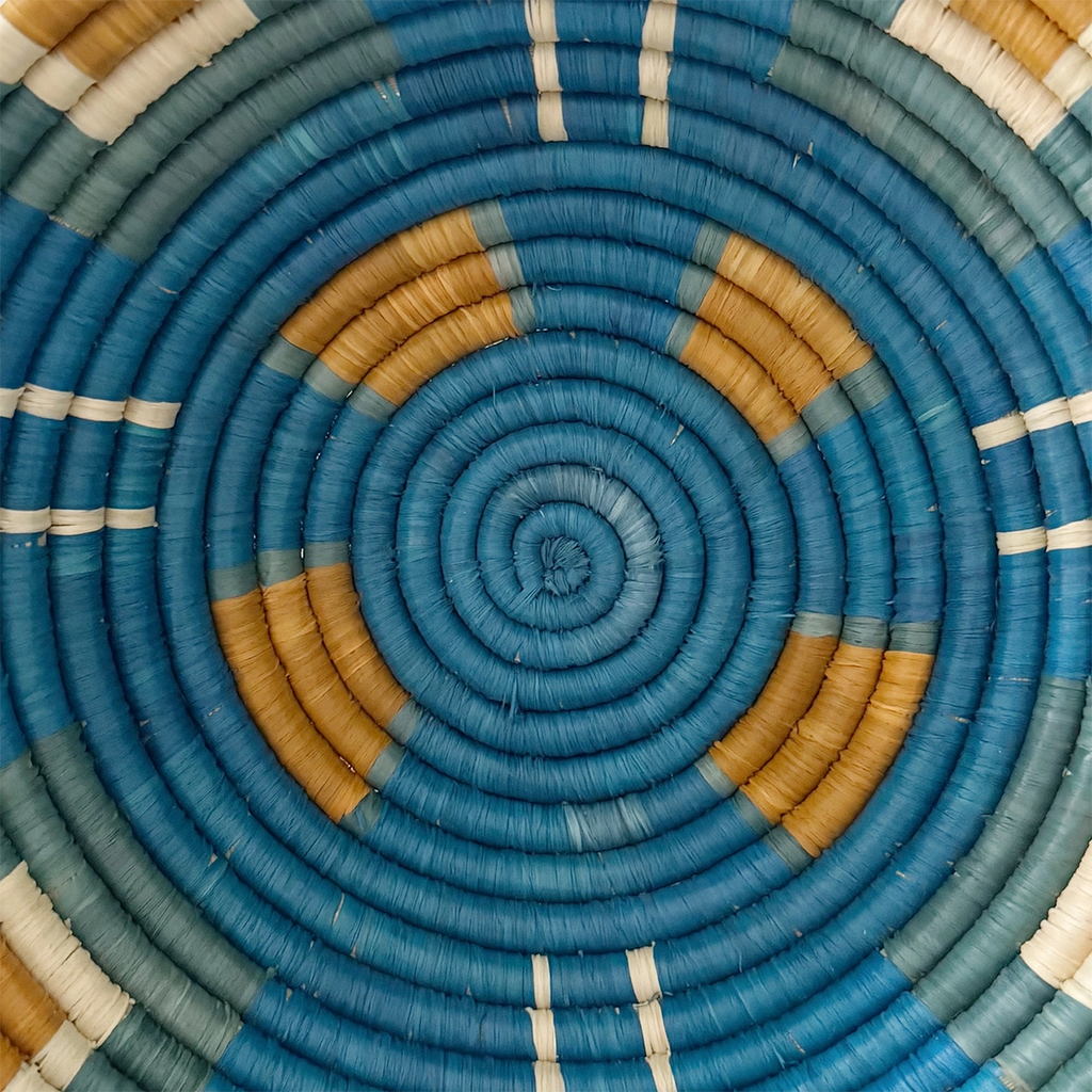 Round handwoven basket with blue background and orange squares and light green clos up