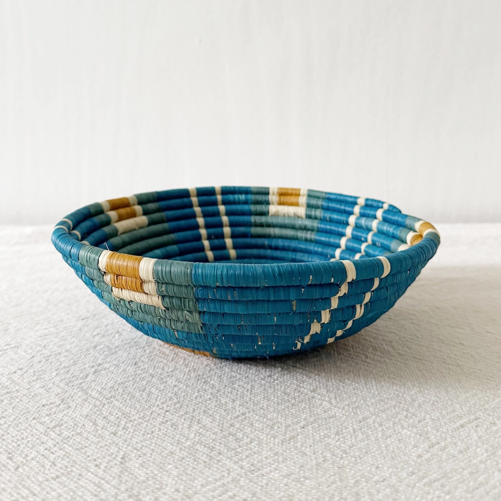 Round handwoven basket with blue background and orange squares and light green