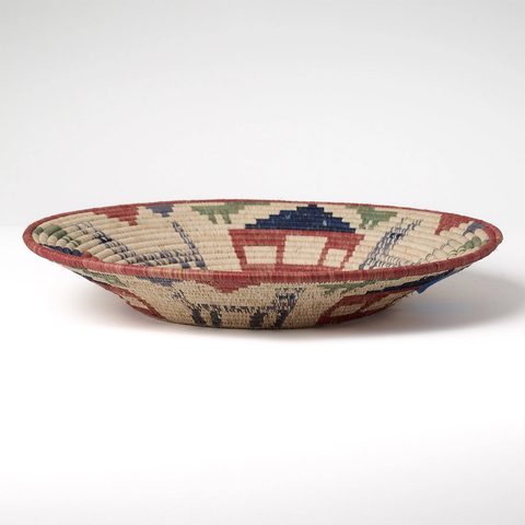 Round banana fiber basket with village scene in rust, green, blue and natural colors