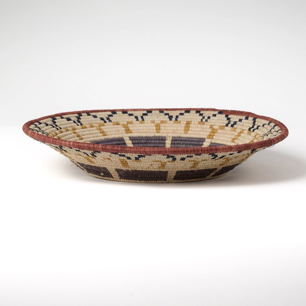 Large round basket natural background with African design in tan, black and gray