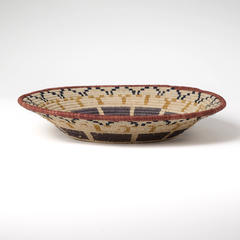 Large round basket natural background with African design in tan, black and gray