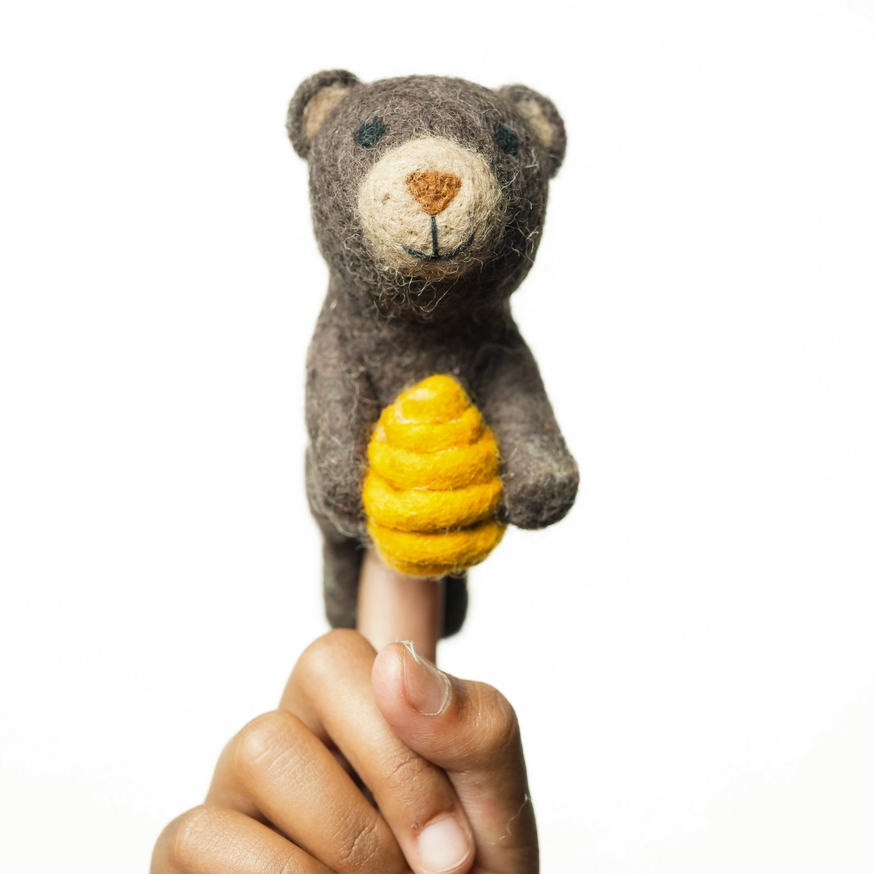Felted wool finger puppet bear with honey comb on finger
