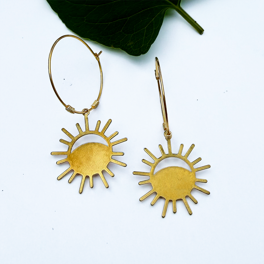 Brass hoop earrings with eclipse charm on the bottom