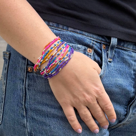 Set of 12 seed bead bracelets with orange, turquoise, purple and gold beads