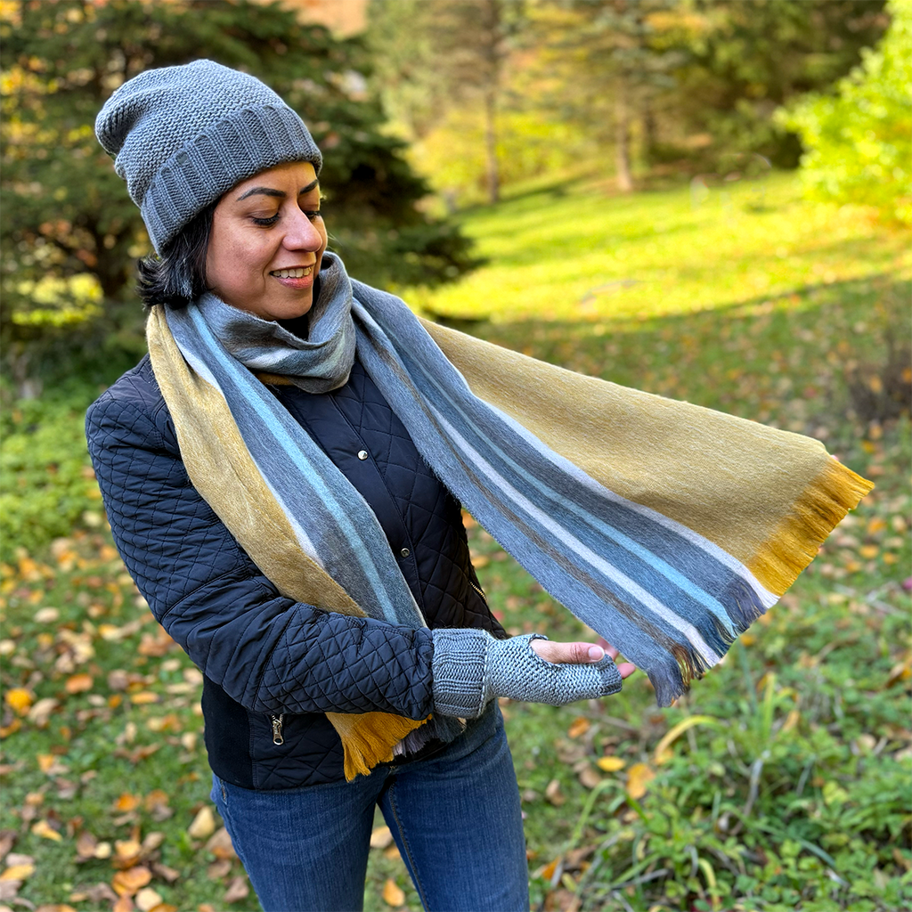 Alpaca scarf on model with gold, gray and blue stripes