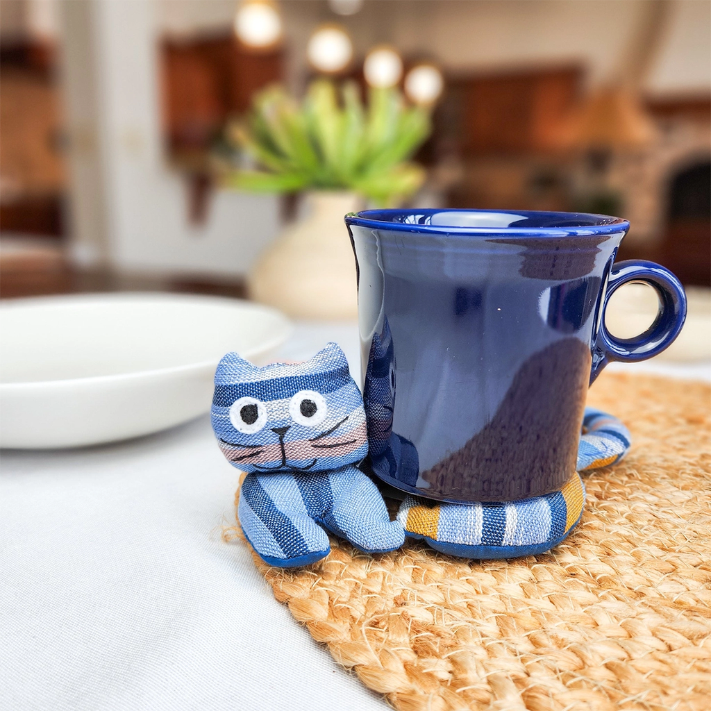 Spiral trivet with cat design  mug on top