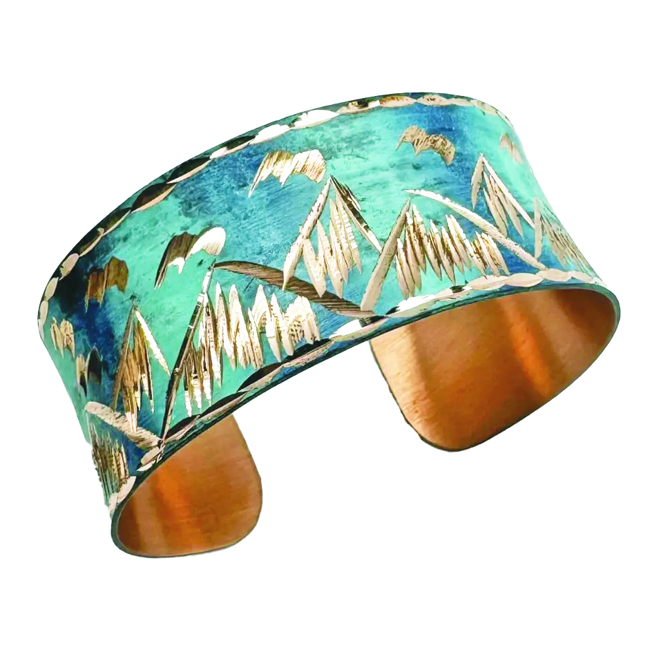 Copper cuff with blue patina and mountain design.