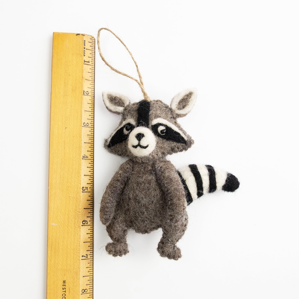 Felted gray raccoon ornament next to ruler