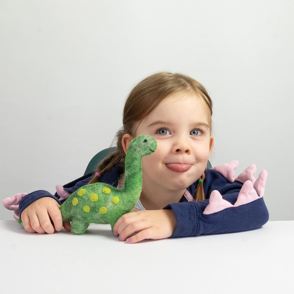 Child playing with green felt dinosaur