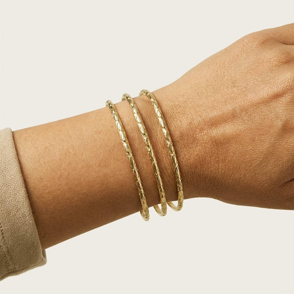 Gold cuff bracelet with 3 strands of metal on hand