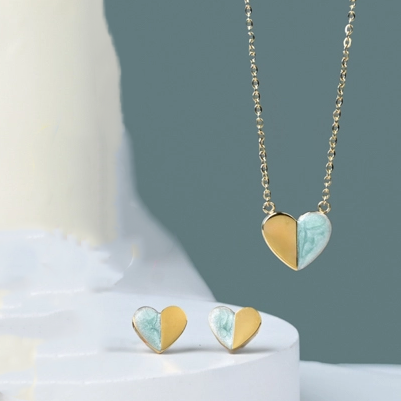 Necklace with a heart pendant that is half gold, half green enamel with delicate gold chain earrings to match