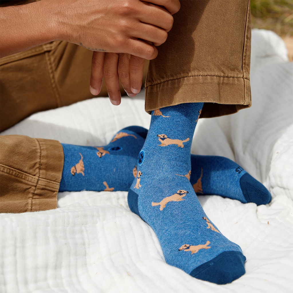 Blue socks with golden retrievers on them on model