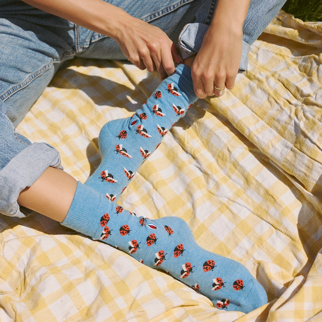 Sky blue socks with ladybugs on model