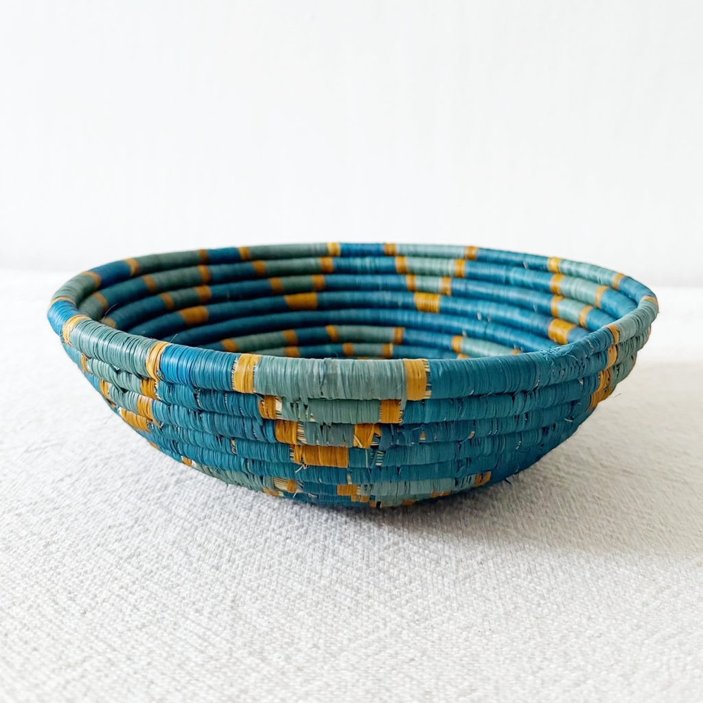 Round handwoven basket with blue star design and orange trim